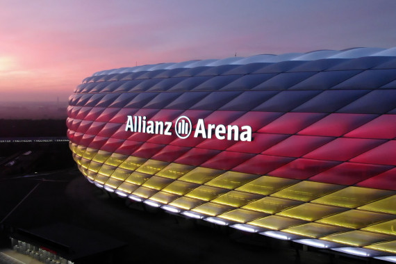 Anlässlich des Starts der Team-D-Einkleidung wurde die Münchner Allianz Arena in den Farben der Deutschlandflagge illuminiert. Footage vom Fotoshoot mit Eric Frenzel, Vinzenz Geiger, Claudia Pechstein, Michelle Uhrig sowie Drohnenbilder von der beleuchteten Arena.