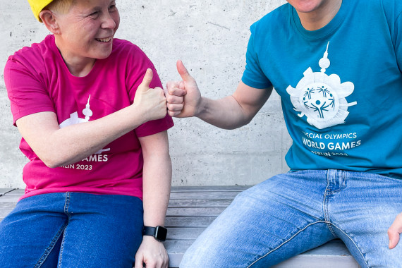 Athletin Daniela Huhn (l.) und Tobias Trollst (Organisationskomitee der Weltspiele 2023) haben sich im Webshop eingedeckt.