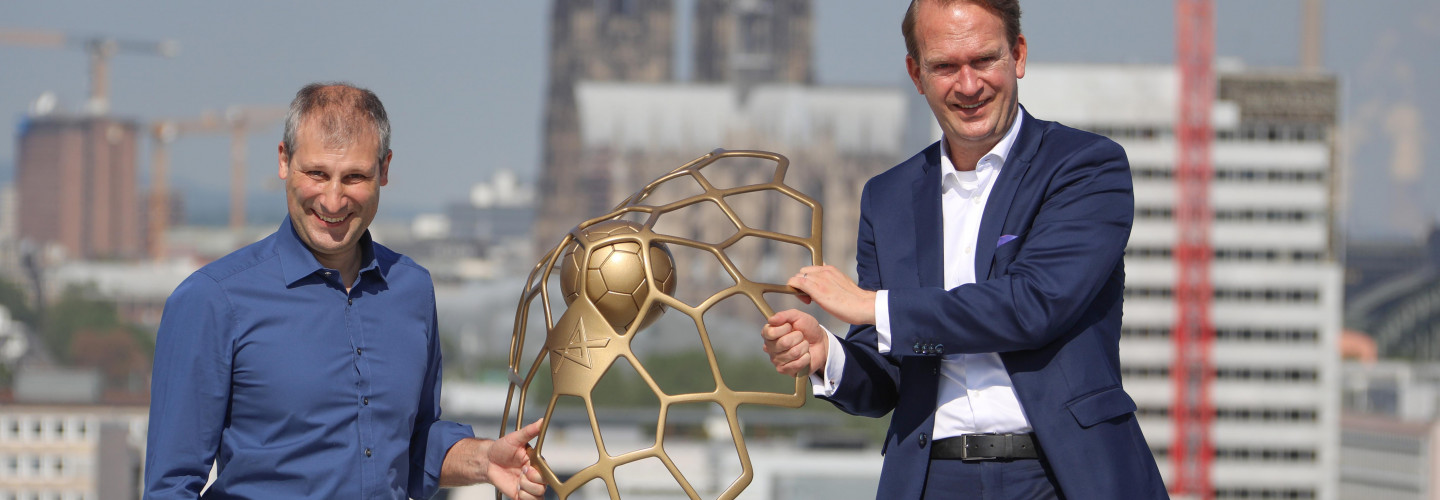 Auf dem Dach der LANXESS arena übergab David Szlezak, Geschäftsführer der EHF-Marketing GmbH, symbolisch die EHF Champions League Trophy an Arena-Geschäftsführer Stefan Löcher und die LANXESS arena. 
