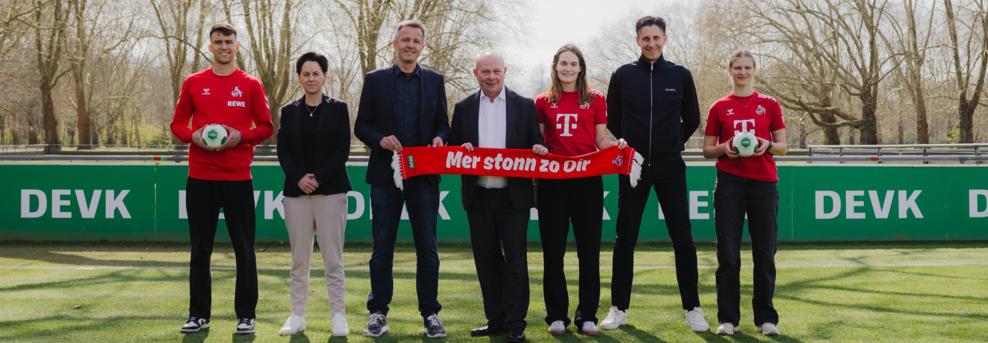 DEVK-Vorstandsvorsitzender Gottfried Rüßmann mit Funktionären und Spieler:innen des 1. FC Köln